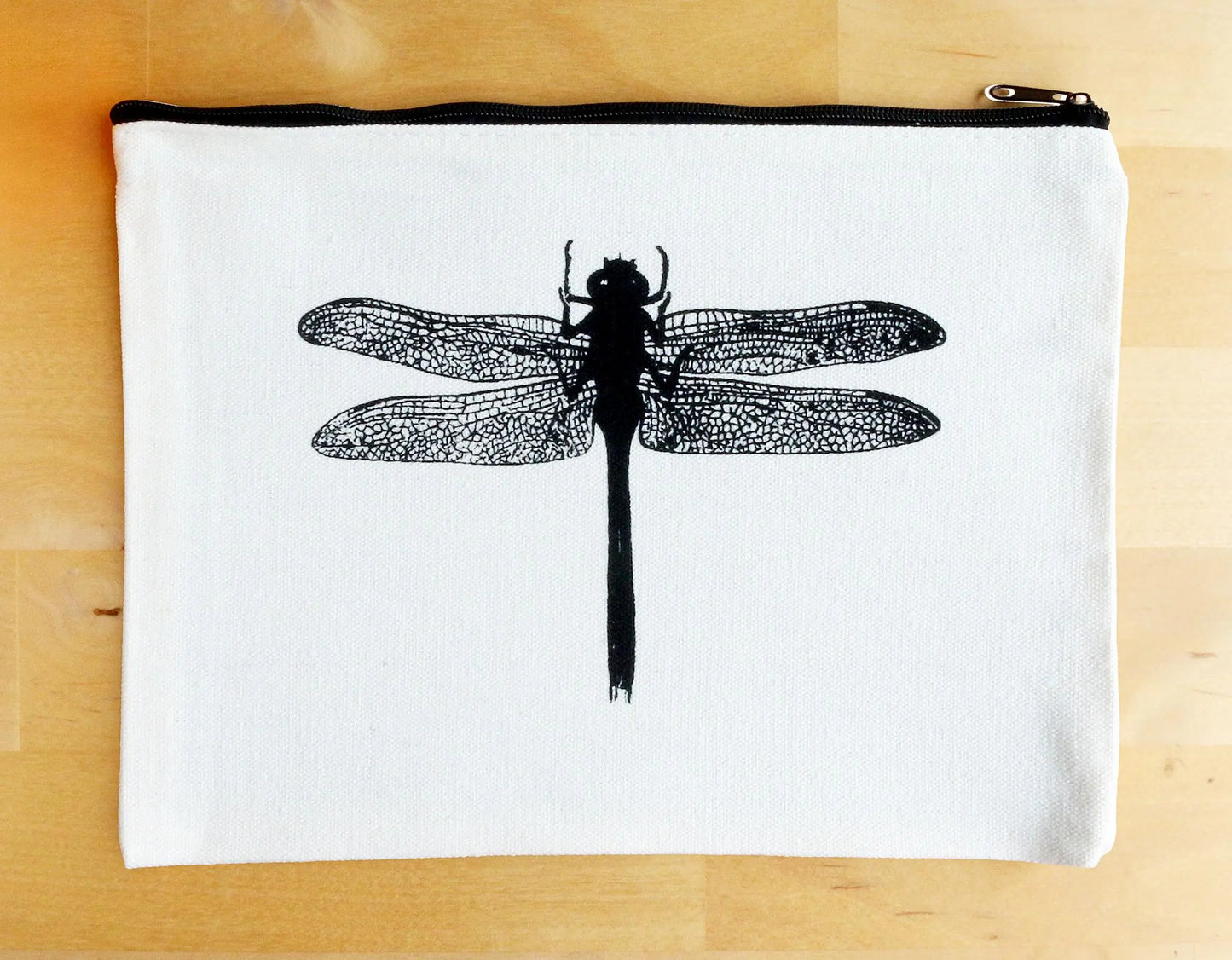 White zipper pouch with black screen-printed dragonfly design, minimalist style